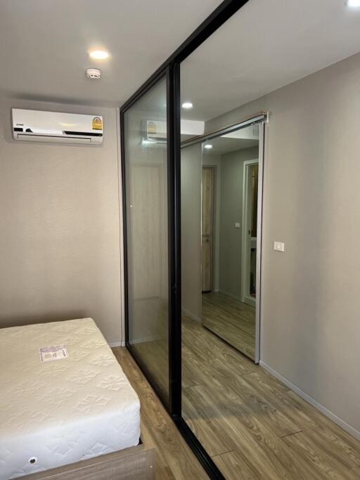 Modern bedroom with sliding mirrored wardrobe doors and air conditioning unit