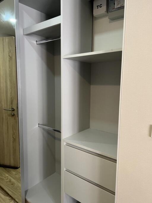 Spacious bedroom closet with open shelves and hanging rods