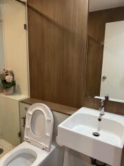 Modern bathroom with white fixtures and wooden accents