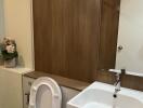 Modern bathroom with white fixtures and wooden accents