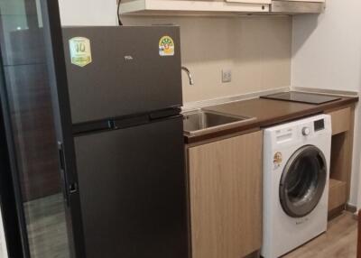 modern kitchen with refrigerator, microwave, and washing machine