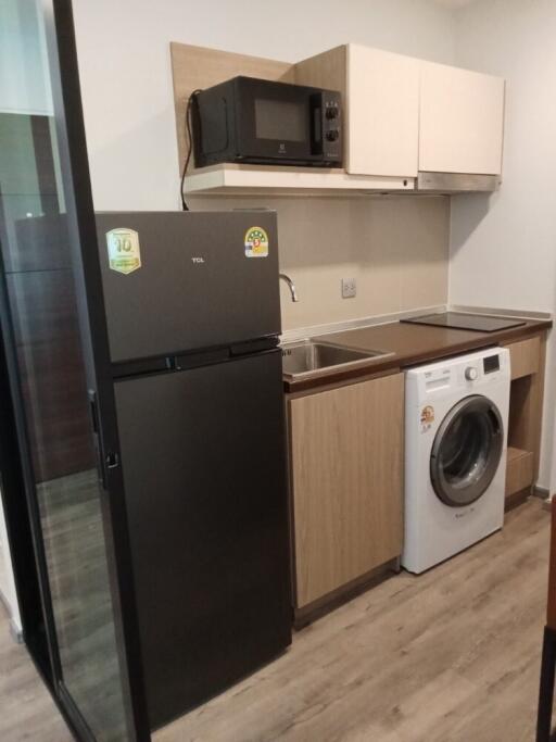 modern kitchen with refrigerator, microwave, and washing machine