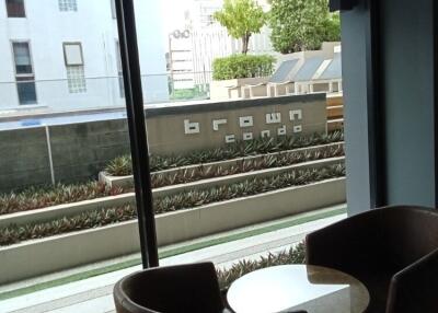 Living area with floor-to-ceiling window and view of the building