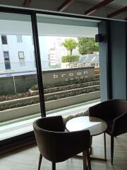 Living area with floor-to-ceiling window and view of the building