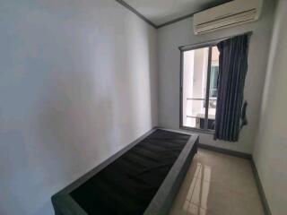 Small bedroom with a single bed, window, and air conditioning unit