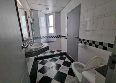 Modern bathroom with checkered floor tiles and large mirror