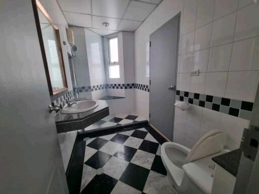 Modern bathroom with checkered floor tiles and large mirror