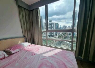 Bedroom with large window and city view