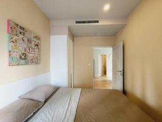 Bedroom with double bed, art on wall, and white wardrobe