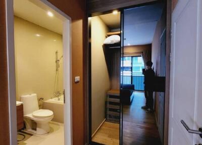 Hallway connecting bathroom and living space with wooden flooring and a mirrored sliding door