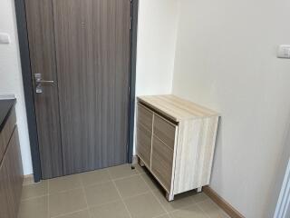 Entryway with wooden door and small cabinet