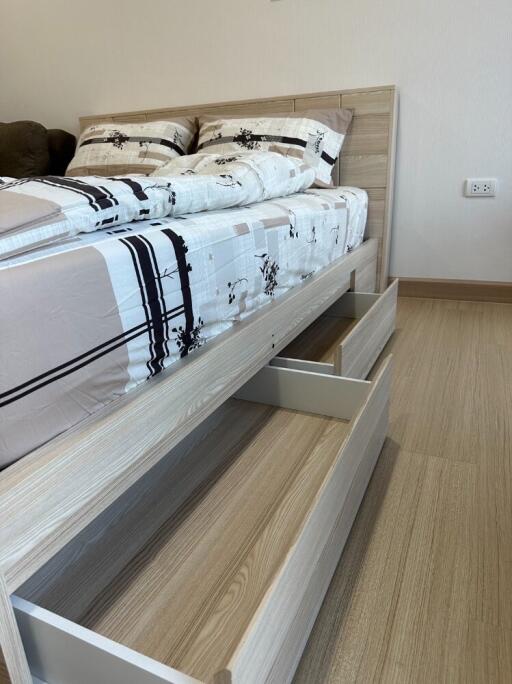 Bedroom with a neatly made bed and under-bed storage drawers