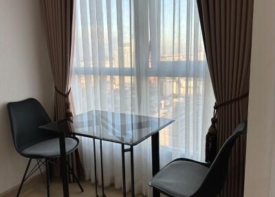 Living room with a small table and two chairs near a window with curtains