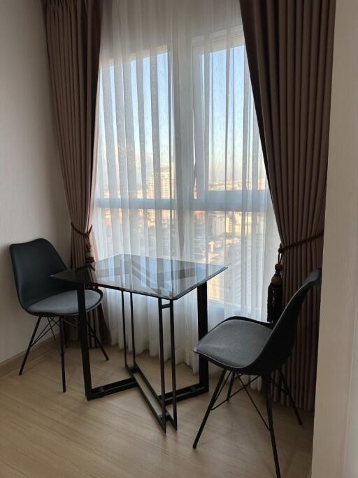 Living room with a small table and two chairs near a window with curtains