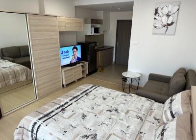 Studio apartment with bed, sofa, TV, kitchen, and wardrobe