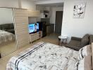 Studio apartment with bed, sofa, TV, kitchen, and wardrobe