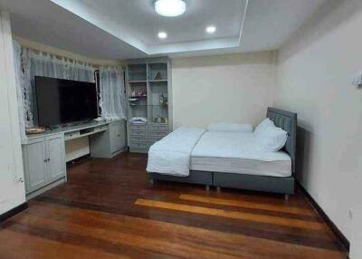 Bedroom with a TV, hardwood floors, and a double bed