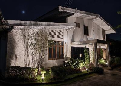 Facade of a house at night with exterior lighting