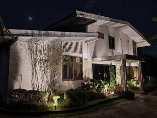 Facade of a house at night with exterior lighting