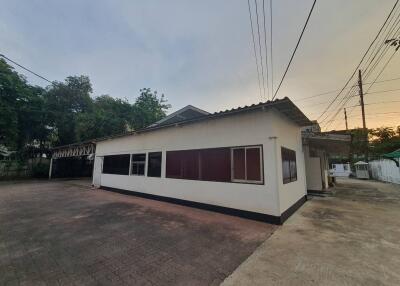 Exterior view of a single-story building with parking area