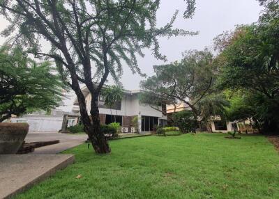 Exterior view of a modern house with a green lawn and trees