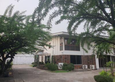 Two-story residential building surrounded by greenery