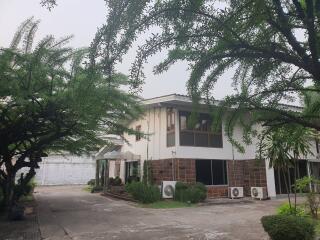 Two-story residential building surrounded by greenery