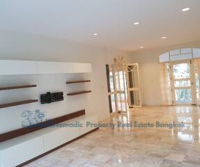 Spacious living room with modern built-in shelving and marble flooring