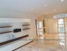 Spacious living room with modern built-in shelving and marble flooring