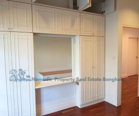 Bedroom storage area with built-in white cabinets