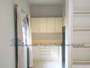 Small kitchen area with cabinets and sliding door