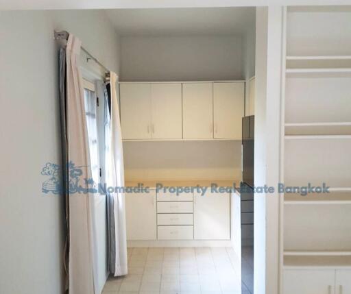 Small kitchen area with cabinets and sliding door