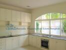 Spacious modern kitchen with large windows and built-in cabinets