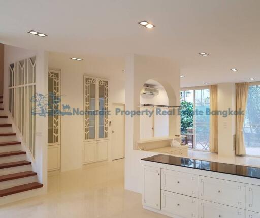 Spacious and bright main living area with modern kitchen and staircase