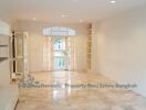 Spacious living room with marble floor, built-in shelves, and large windows