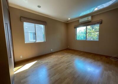 Empty bedroom with wooden floor and large windows