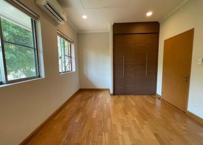 Empty bedroom with wooden flooring and large windows