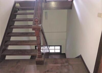 Wooden staircase with dark wooden handrails and steps