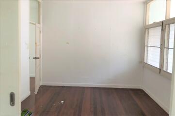 Empty bedroom with wooden floor and large windows