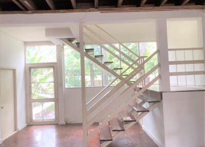 Spacious living area with staircase and large windows