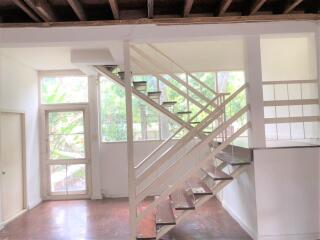 Spacious living area with staircase and large windows