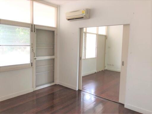 Bedroom with wooden flooring and air conditioning