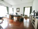 Spacious home office with large windows and wooden floor