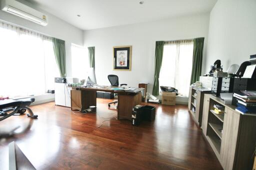 Spacious home office with large windows and wooden floor