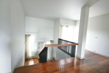 Modern staircase with wooden steps and black railings in a bright home