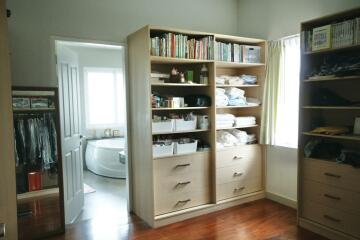 Organized bedroom with large shelves and walk-in closet