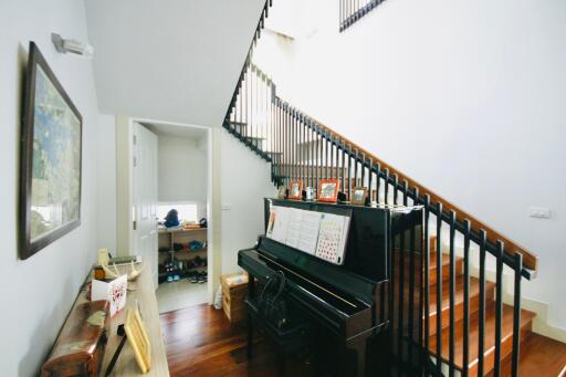 Bright stairway area with piano and picture frames