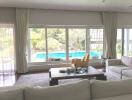 Spacious living room with pool view through large windows