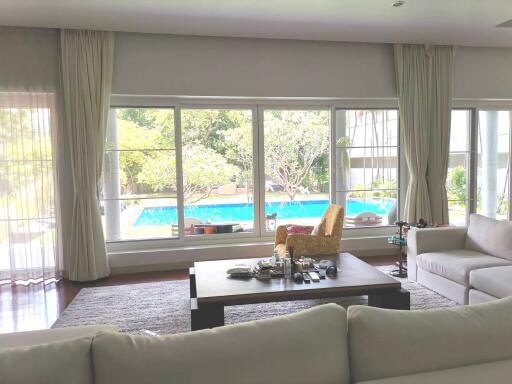 Spacious living room with pool view through large windows