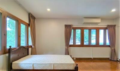 Spacious bedroom with hardwood floors and large windows